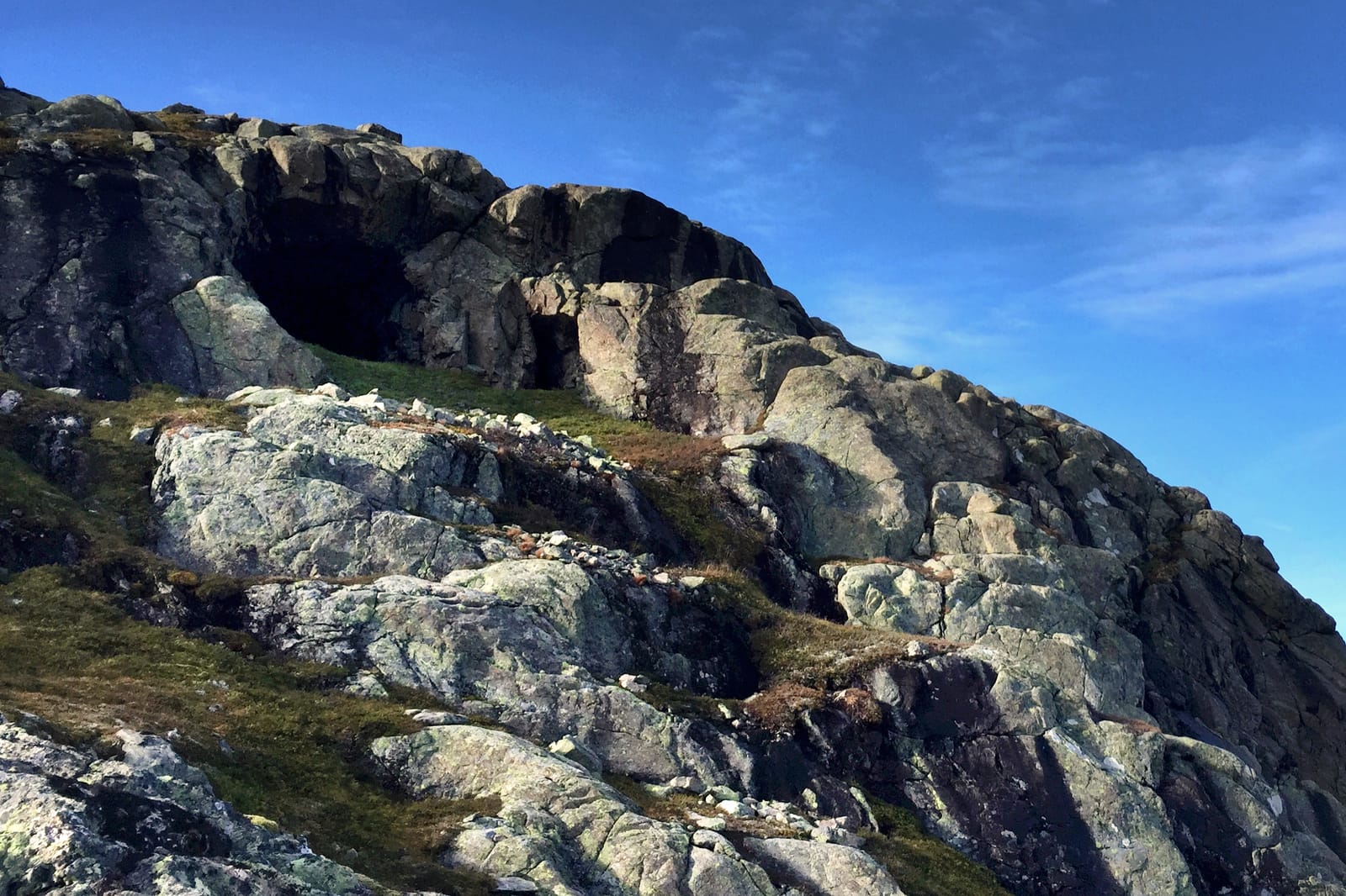 Bjødnehiet i Vollbotn – et naturlig formet hulrom i fjellet, omringet av steinformasjoner og villmark under en blå himmel.